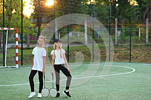 Two girls after lessons go in for tennis on the playground.