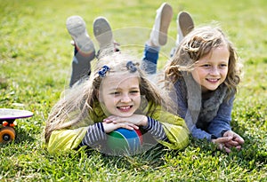 Two girls lie on grass