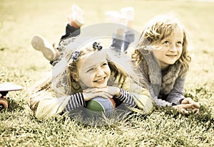 Two girls lie on grass