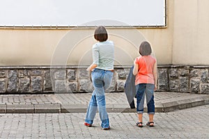Two girls look at advertising banner