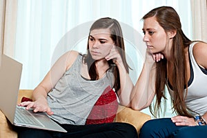 Two girls looking at a lap top.