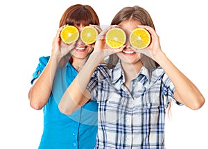 Two girls are looking through oranges