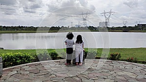 Two little girls staring at the lake on a cloudy day photo