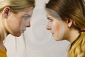 Two girls looking serious at each other