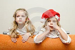 Two girls looking to left leaning back on the couch