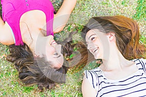 Two girls lying on the grass and laughing