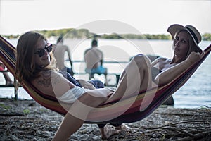 Two girls lying on a lounge at the beach in summer