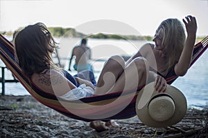 Two girls lying on a lounge at the beach in summer