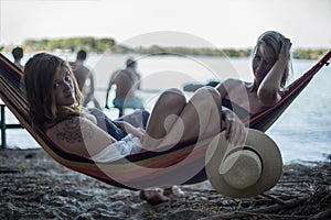 Two girls lying on a lounge at the beach in summer