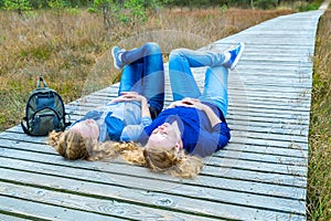 Two girls lying on their backs in nature