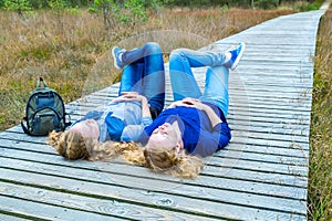 Two girls lying on their backs in nature photo