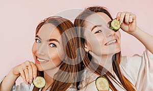 Two girls make homemade face beauty masks. Cucumbers for the freshness of the skin around the eyes. Women take care of youthful