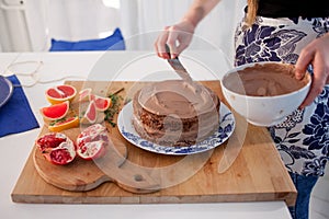 Two girls making a cake on the kitchen. Womens hands, causing the chocolate cream