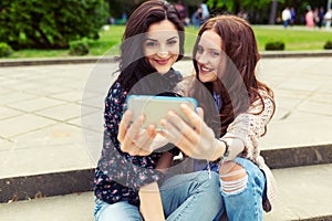 Two girls making funny selfie on the street, having fun together