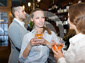 Two girls with man at bar