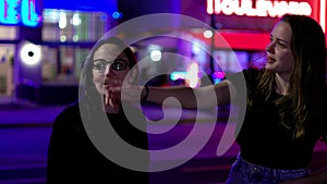 Two girls at Miami Beach at night - the colorful Ocean Drive of South Beach