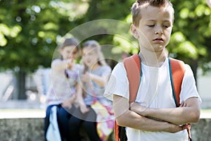 Two girls mocking a boy