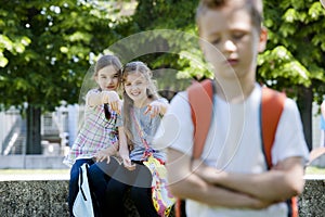 Two girls mocking a boy