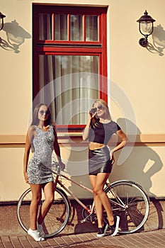 Two girls near a vintage bike
