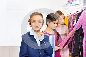 Two girls and one boy with shopping bag in store