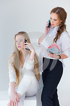 Two girls, one calls making an order, the second girl accepts an order