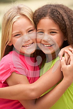 Two Girls In Park Giving Each Other Hug