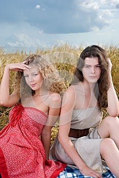 Two girls on picnic in wheat field