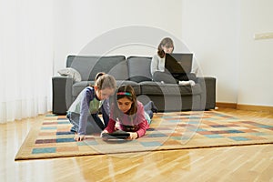 Two girls play in the living room while their mother teleworks