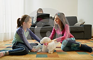 Two girls play in the living room while their mother teleworks