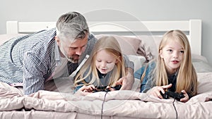 Two girls play video games with grandparent