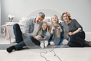 Two girls play video games with grandparents