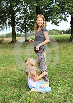 Two girls playing and standing on each other