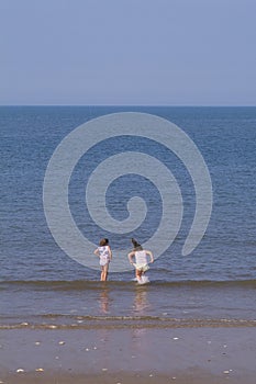 Two girls playing in waves