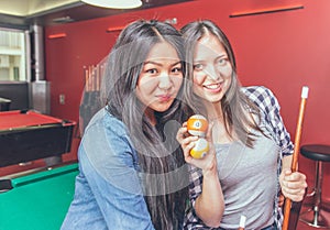 Two girls portrait in a biliard room.