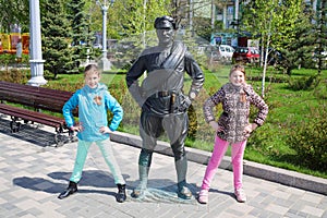 Two girls pose near Monument of Sukhov