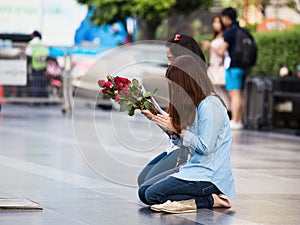 Two girls, pray before a Buddhist temple in Bangkok, Thailand