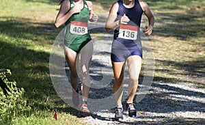 Two girls racing downhill during a chigh school ross country race