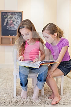 Two girls read a book photo