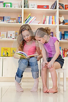 Two girls reading a fascinating book photo