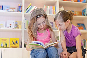 Two girls are reading an interesting book photo