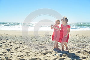 Two girls in red dress on the beach