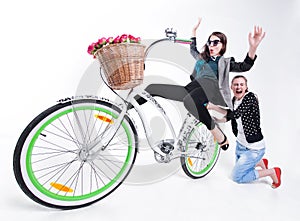 Two girls riding a bike making funny faces - on bluish background
