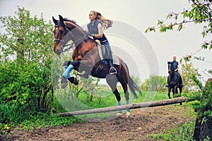 Two girls riding horses on countryside