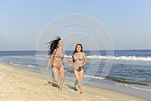 Two girls running on the beach