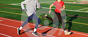 Two girls running fast together on a track