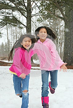 Two girls running through the snow