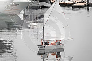 Two girls are sailing on a small sailing boat