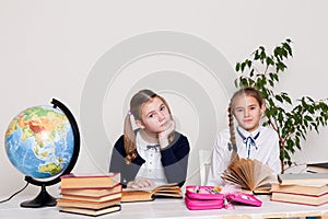 Two girls in the school geography lesson study knowledge in the classroom