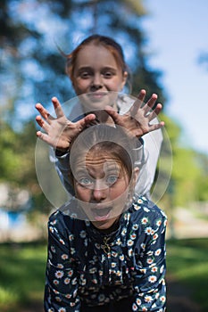 Two girls sisters or girlfriends having fun outdoors.