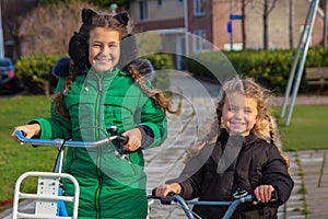 Two girls sisters ride bicycles. Dutch kids enjoy cycling every day